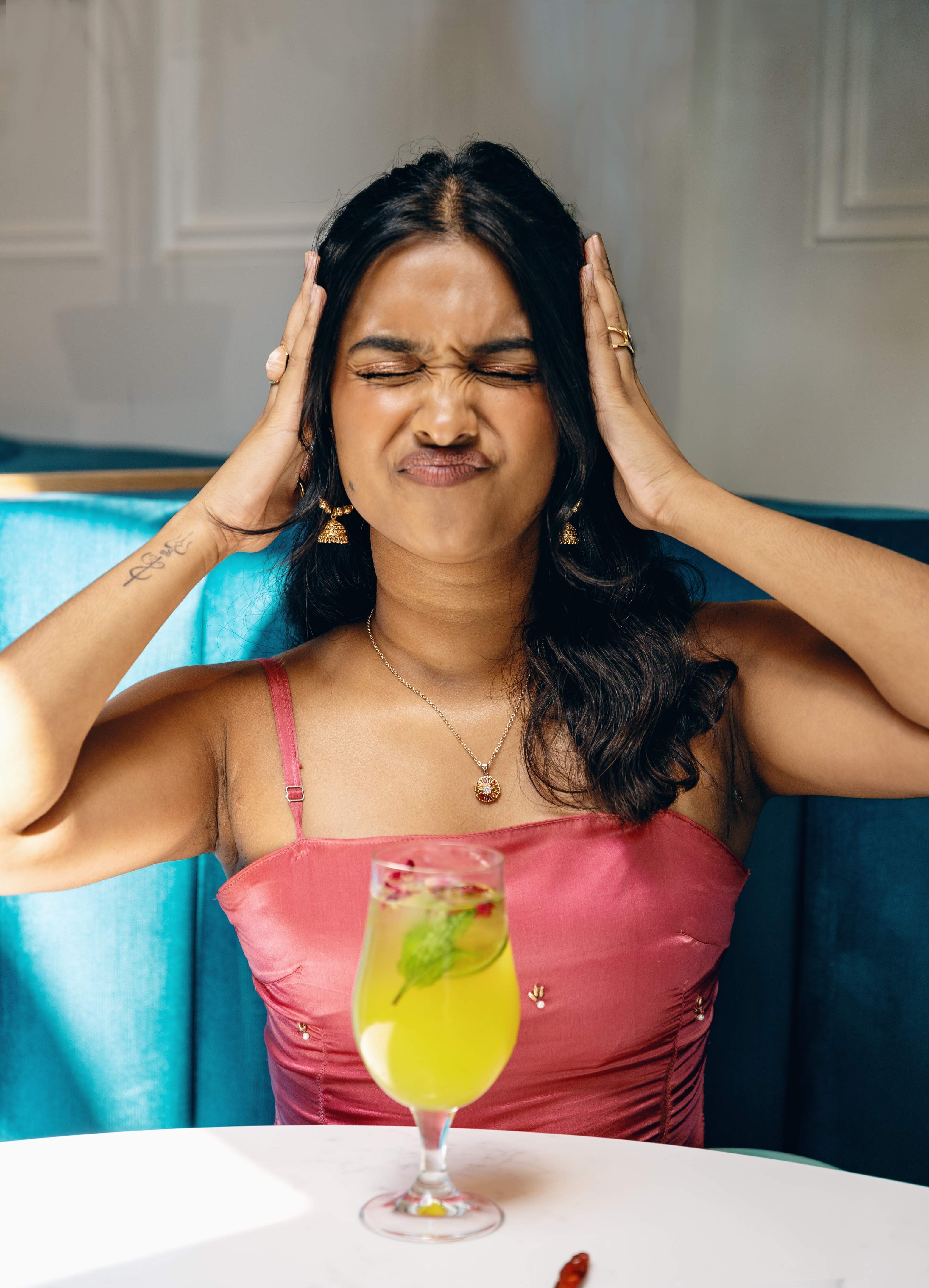 Eyes shut, mid-laugh in a pink saree