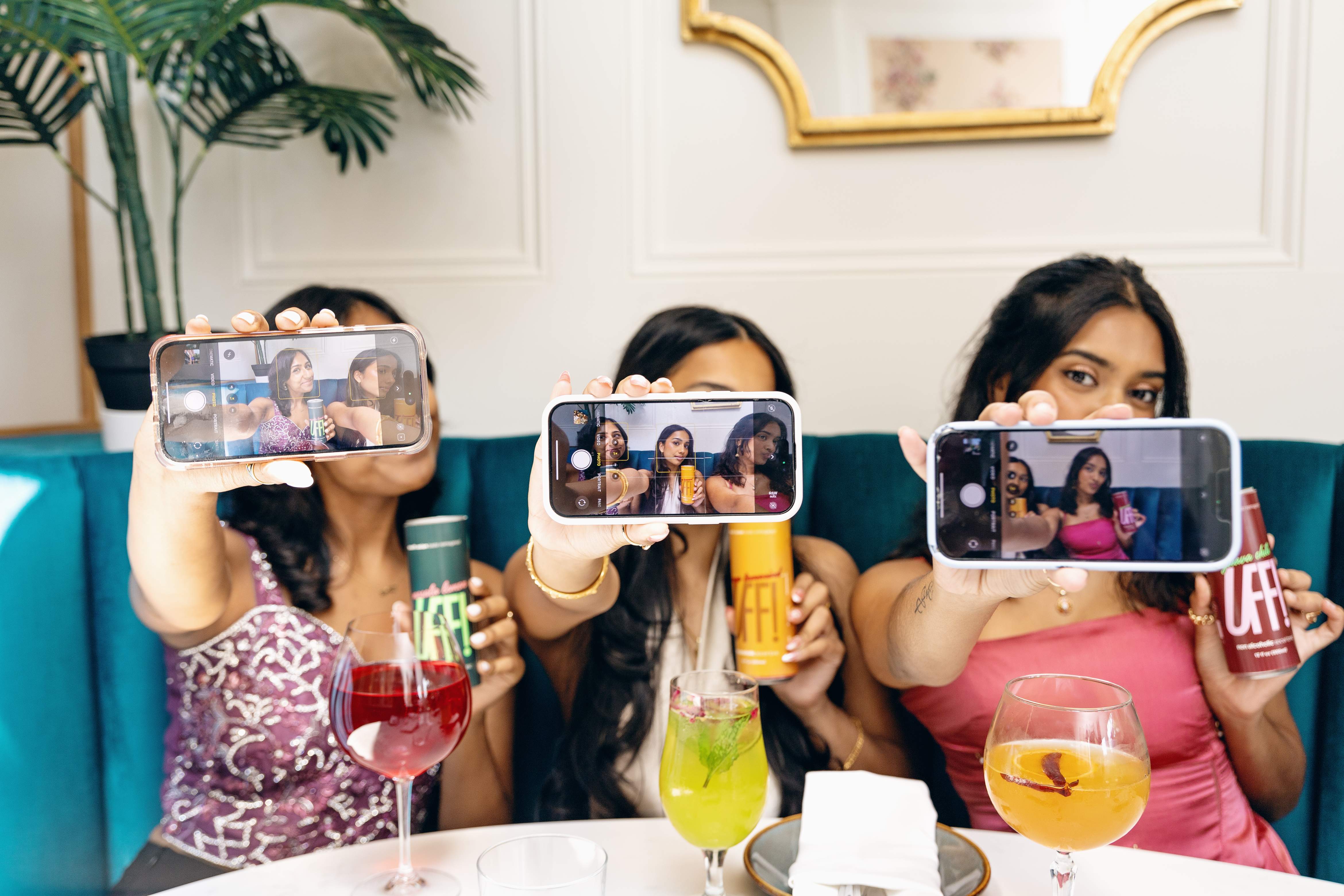 The whole table up on their phones, mid-selfie